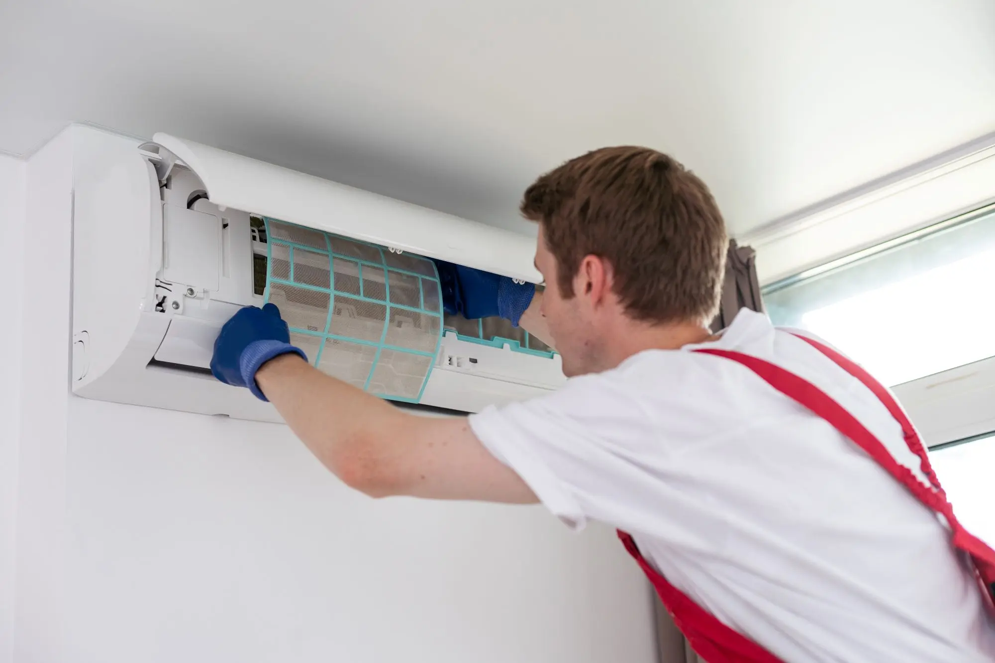 AMC AC technician servicing an air conditioning unit in Dubai